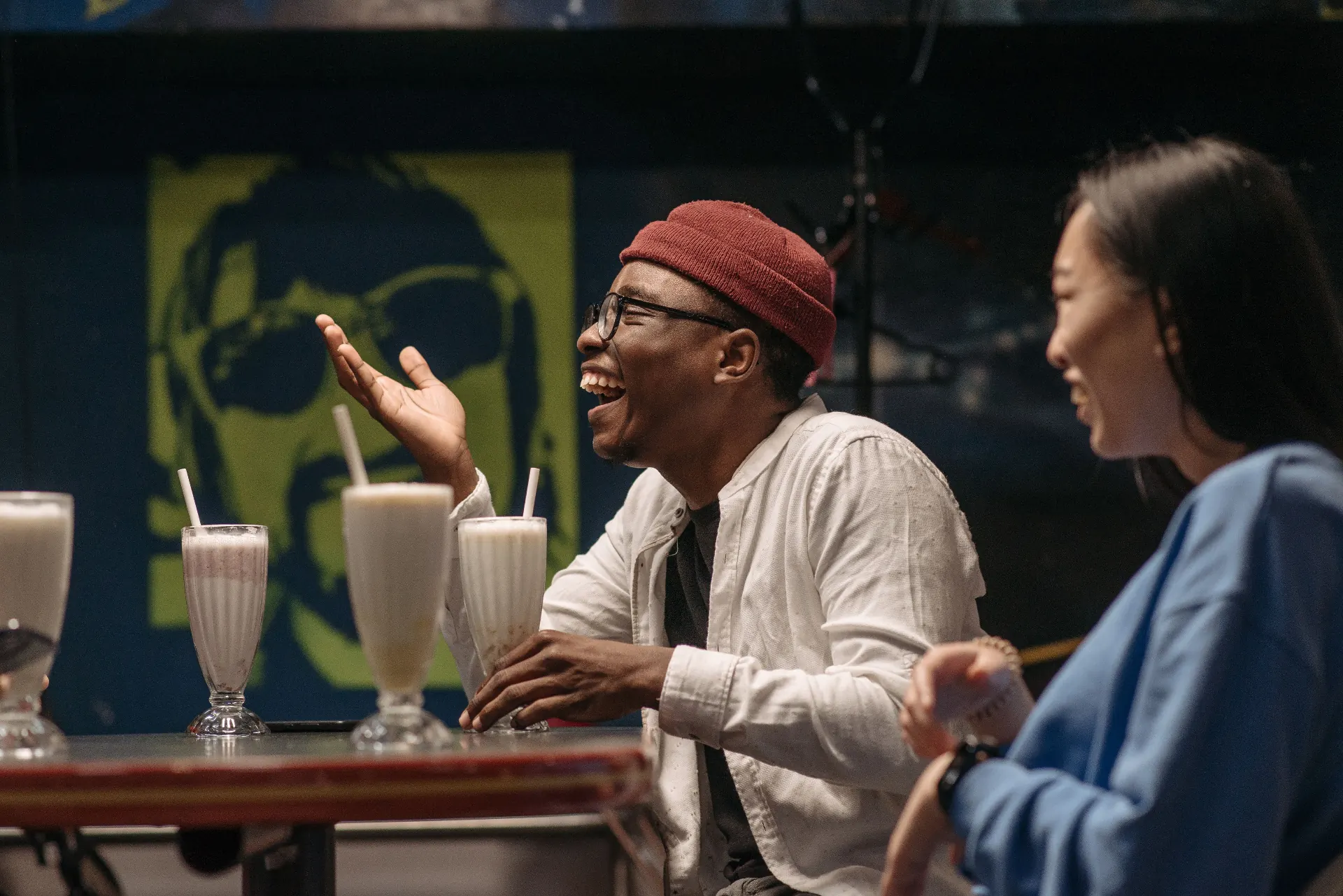 Amigos rindo em uma lanchonete tomando milkshakes